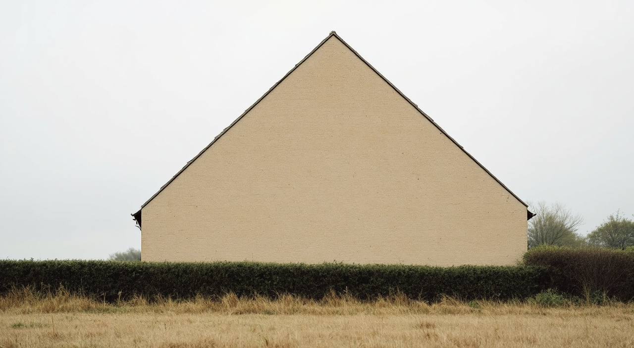 Pignon aveugle d'une maison, grande surface enduite sans ouverture montant en triangle sous rampants
